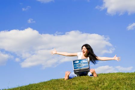 funny woman with laptop on the green grassの写真素材