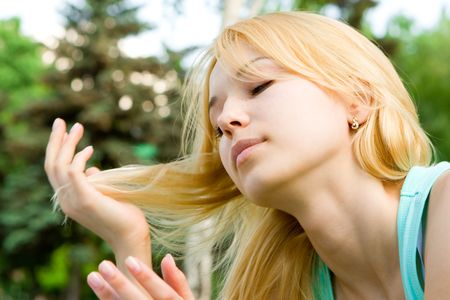 pretty girl playing with hair in the parkの写真素材