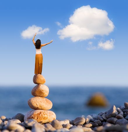 woman and balanced stones on the seaの写真素材