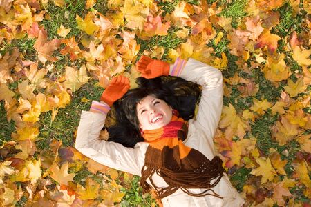 Young pretty woman on the autumn leafの写真素材