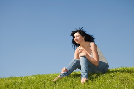 happy young woman rest on the green grass の写真素材