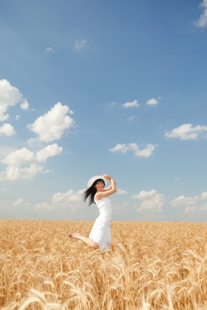 Cute woman in golden wheat の写真素材