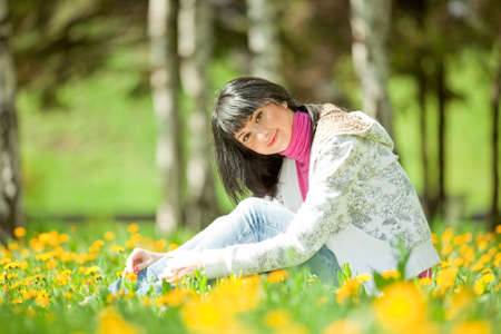 Cute woman in the park with dandelionsの写真素材