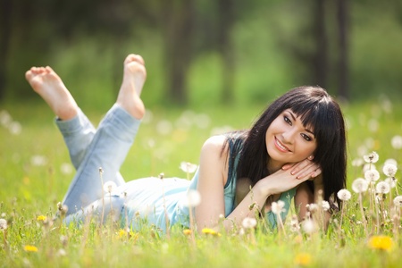 Cute woman in the park with dandelionsの写真素材