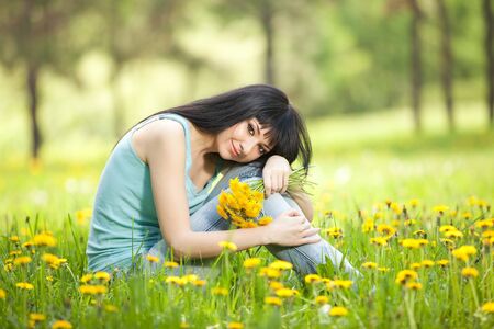 Cute woman in the park with dandelionsの写真素材