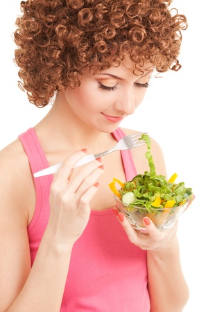 fun woman eating the salad on the white backgroundの写真素材