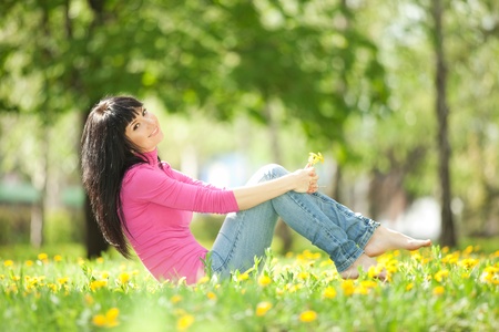 Cute woman in the park with dandelionsの写真素材