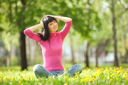 Cute woman in the park with dandelionsの写真素材