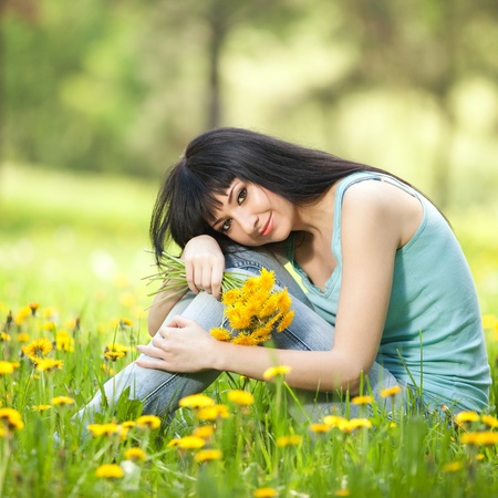 Cute woman in the park with dandelionsの写真素材