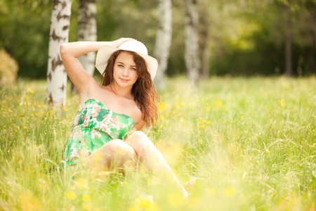 Young redhead woman in the park with flowersの写真素材