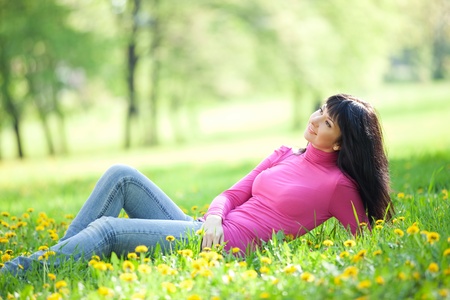 Cute woman in the park with dandelionsの写真素材