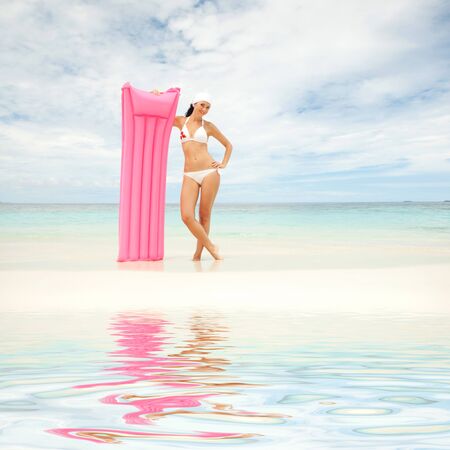 Happy woman with inflatable mattress on the beachの写真素材