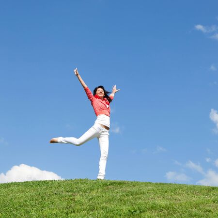 pretty young woman jumping on green grassの写真素材