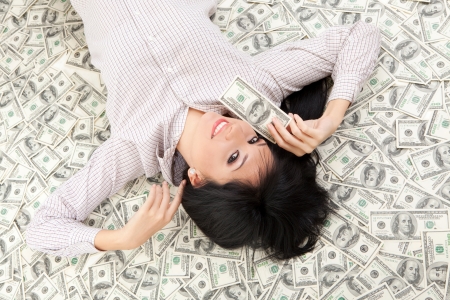 Young business woman resting upon moneyの写真素材
