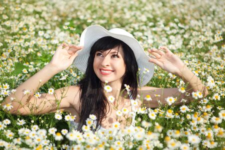 Young happy woman in the daisy fieldの写真素材