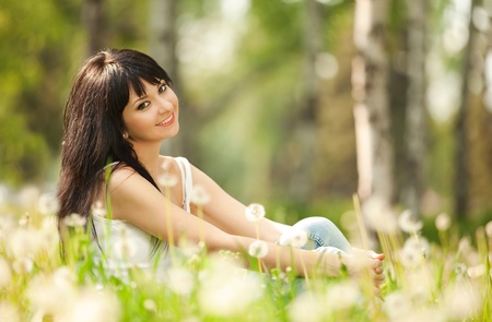 Cute woman in the park with dandelionsの写真素材