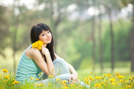 Cute woman in the park with dandelionsの写真素材