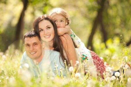 Happy mother, father and daughter in the parkの写真素材