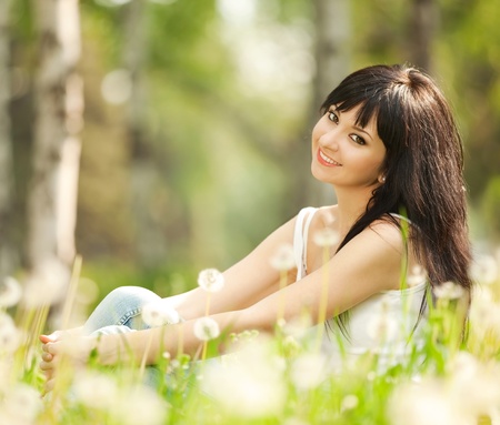 Cute woman in the park with dandelionsの写真素材