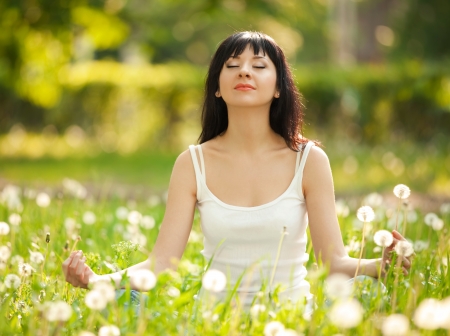 Pretty woman meditate in the parkの写真素材
