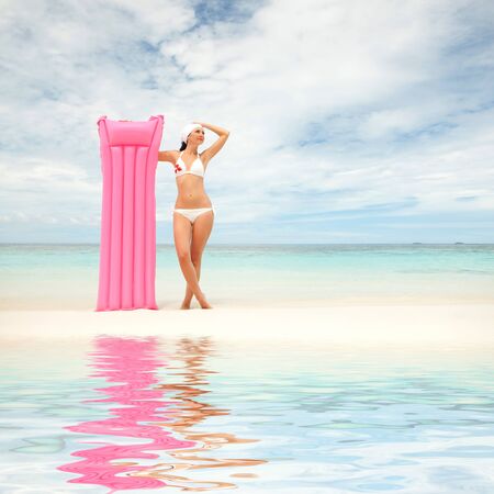 Happy woman with inflatable mattress on the beachの写真素材