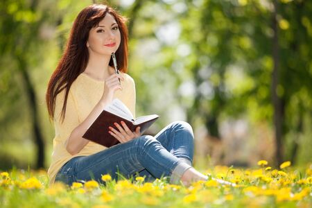 Pensive woman in the park with flowersの写真素材