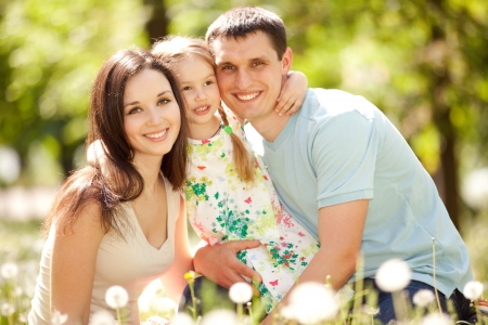 Happy mother, father and daughter in the parkの写真素材