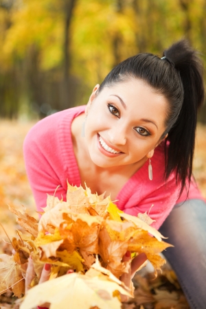 Fun pretty woman playing in the autumn parkの写真素材