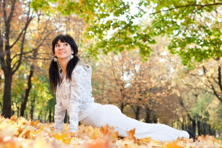 Pretty woman doing yoga exercises in the autumn parkの写真素材