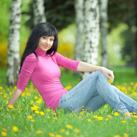 Cute woman in the park with dandelionsの写真素材