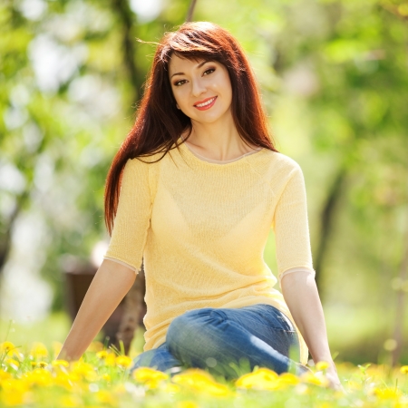 Young redhead woman in the park with flowersの写真素材