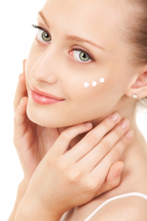 Cute woman applying cream to her faceの写真素材