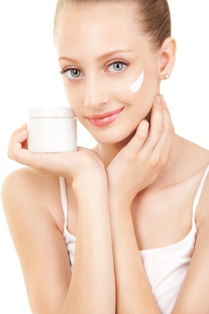 Cute woman applying cream to her faceの写真素材