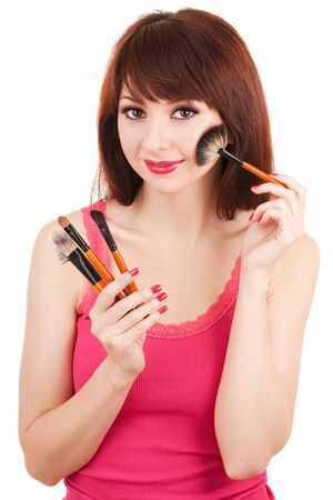 Young woman with brushes for makeup isolated on white backgroundの写真素材