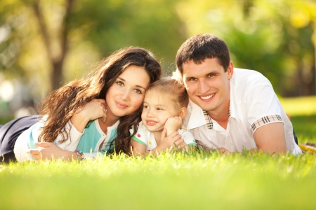 Happy mother, father and daughter in the parkの写真素材