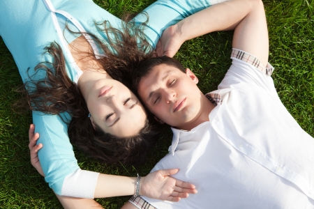 Happy couple relaxing on green grassの写真素材