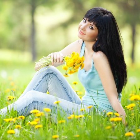 Cute woman in the park with dandelionsの写真素材