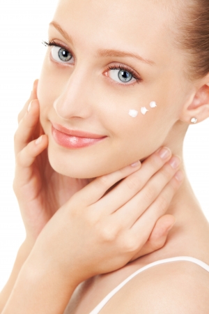 Cute woman applying cream to her faceの写真素材