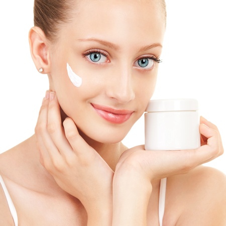 Cute woman applying cream to her faceの写真素材
