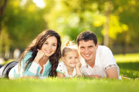 Happy mother, father and daughter in the parkの写真素材