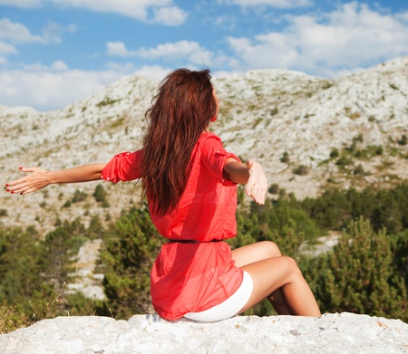 Beautiful woman sitting before the mountains. Life's enjoymentの写真素材