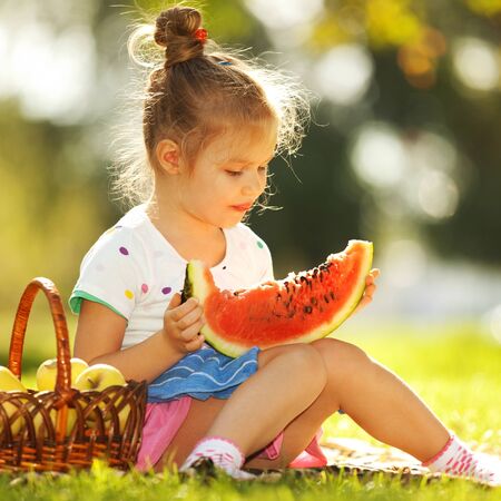 Cute little girl eating watermelonの写真素材