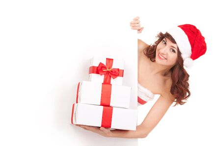 Santa woman with gift boxes looking at white blank boardの写真素材