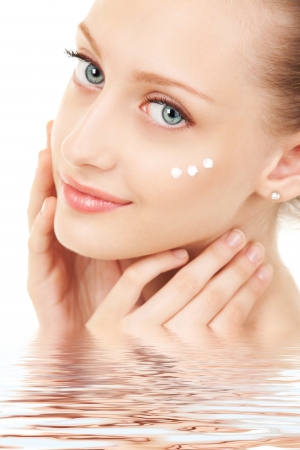 Cute woman applying cream to her faceの写真素材