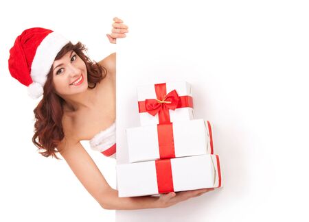 Santa woman with gift boxes looking at white blank boardの写真素材