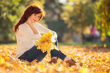 Young pretty woman relaxing in the autumn parkの写真素材