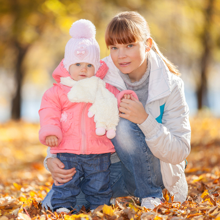 Mother and daughter in the autumn parkの写真素材