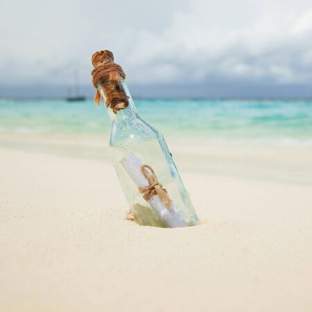 A letter in a bottle on the beach. Island lifestyle. White sand, crystal-blue sea of tropical beach. Ocean beach relax, travel to islandsの写真素材