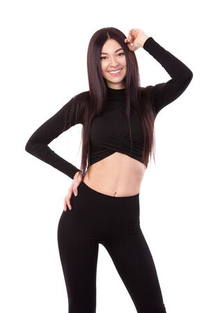 Pretty woman with beautiful long hair in black suit isolated on white background. Close up of sporty and beautiful female body. Tanned brunette with long hair. Healthy lifestyle, dieting, fitness, weight lossの写真素材