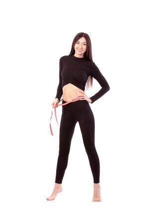 Pretty woman in black suit isolated on white background Close up of sporty and beautiful female body. Woman with measure tape. Healthy lifestyle, dieting, fitness, weight loss conceptの写真素材